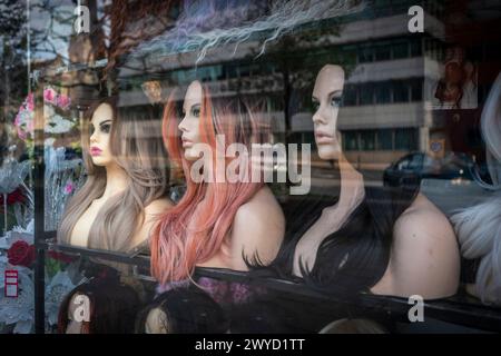 Drei Perücke Schaufensterpuppen in einem Fenster für einen Laden, der Haarverlängerungen entlang der Commercial Street in Southampton, Hampshire, England, Großbritannien verkauft Stockfoto