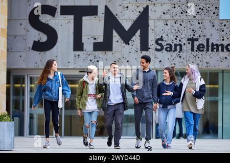 Junge Menschen, die auf der Plaza Zuloaga spazieren, Außenfassaden des San Telmo Museums, Donostia, San Sebastian, Gipuzkoa, Baskenland, Spanien. Stockfoto