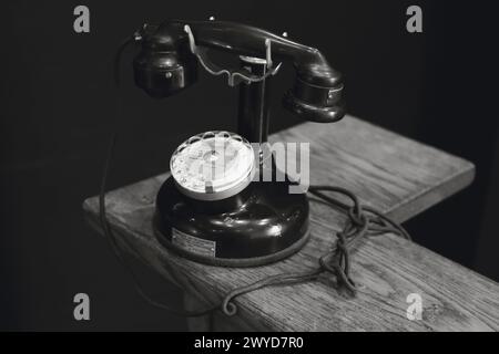 Ein klassisches, schwarzes Drehwahlteltelefon liegt auf einem Holzregal und erinnert im Molinard Parfümerie Museum in Grasse, Frankreich, an Nostalgie Stockfoto