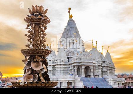 Malerische hindu-Statue mit Akshardham Mahamandir-Tempel hinten am BAPS Swaminarayan Akshardham bei goldenem Sonnenuntergang Stockfoto