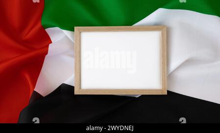 Leere weiße Papierrahmenvorlage nationales Symbol der VAE. Kleine Flagge der Vereinigten Arabischen Emirate mit Wanderfalke auf neutralem beigem Hintergrund. Kopieren Sie den Platz für Ihren Text. Das Konzept der Unabhängigkeit des Nationaltages Stockfoto