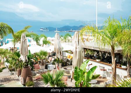 Fantastischer Blick auf die Lounge (Privatstrand mit Bar) an der Küste von Cannes, Aussicht, - Blick von Croisette. Bluree-Leute (vielleicht garson oder Kellner). Stockfoto