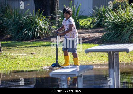 Samstag, 6. April 2024. Sydney wurde in den letzten 48 Stunden von einer Regenflut heimgesucht, wobei einige Gebiete, darunter Penrith, die stärksten Regenfälle aller Zeiten hatten. In Narrabeen wurden Bewohner um die Narabeen Lagune gebeten, wegen des steigenden Wasserspiegels vom Narrabeen Lake an den nördlichen Stränden von Sydney zu evakuieren. wo über 150 mm Regen gefallen sind. In New South Wales gab es mehr als 50 Hochwasserwachen entlang der Flüsse und es wird erwartet, dass der Warragamba-Damm ausläuft. Junge in gelben Stiefeln spielt auf seinem Roller im Hochwasser. Martin Berry @alamy Live News. Stockfoto