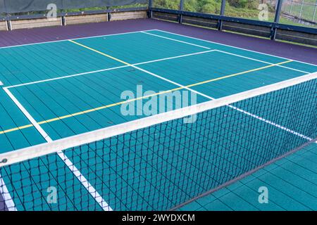 Elevated Platform Tennis, Paddle Ball Courts mit gelben Pickelballlinien und Netz. Die Bodenfläche ist grün mit weiß und gelb Stockfoto