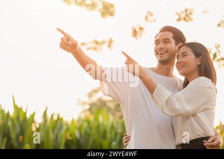 Zwei Teenager stehen glücklich lächelnd zusammen Park im Freien, sonnenstrahlende Hand, die hoch zeigt für Lebensplanung zukünftige Versicherungsvision Konzept Stockfoto