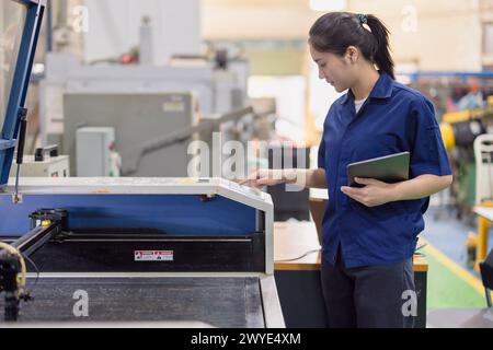 Asiatische Arbeiterinnen arbeiten in der Schwerindustrie mit CNC-Drehmaschine Fräsen Metallmaschine in Stahlproduktfabrik Stockfoto