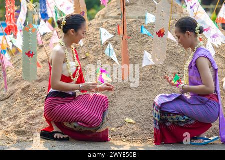 Songkran Festival. Nordthailändische Menschen in traditioneller Kleidung tragen Sand in den Tempel, um Sandpagode und Dekoration mit farbenfrohen PA zu bauen Stockfoto