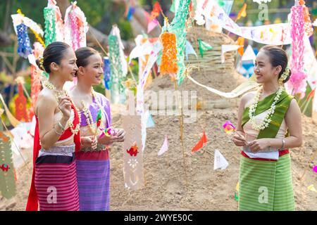 Songkran Festival. Nordthailändische Menschen in traditioneller Kleidung tragen Sand in den Tempel, um Sandpagode und Dekoration mit farbenfrohen PA zu bauen Stockfoto