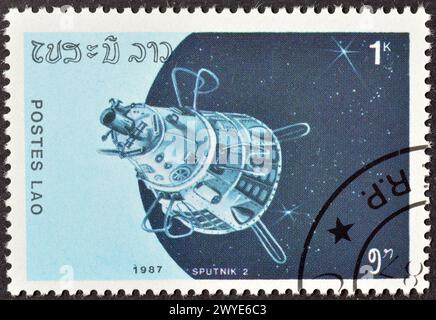 Gestempelte Briefmarke von Laos, die Satellit 'Sputnik-2' zeigt, um 1987. Stockfoto