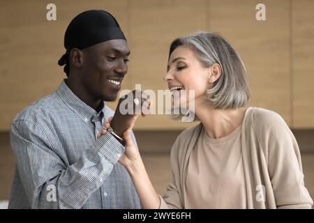 Glückliches, multiethnisches reifes Paar genießt romantisches Date in der Küche Stockfoto