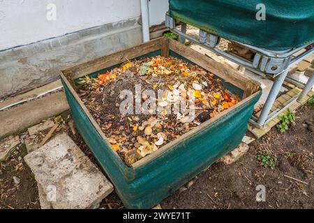 Kompostbehälter mit Lebensmittelresten, Grasschnitt, Unkraut und organischen Resten als natürlicher Dünger Stockfoto