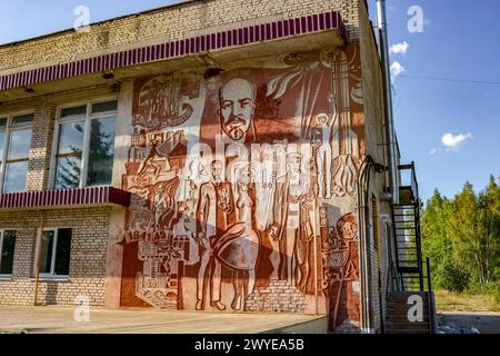 Vysokinichie, Russland - August 2018: Panno aus der Sowjetzeit auf dem Clubgebäude im Dorf Vysokinichi. Die Platte wird in Sgraffito-Technik hergestellt. Kalu Stockfoto