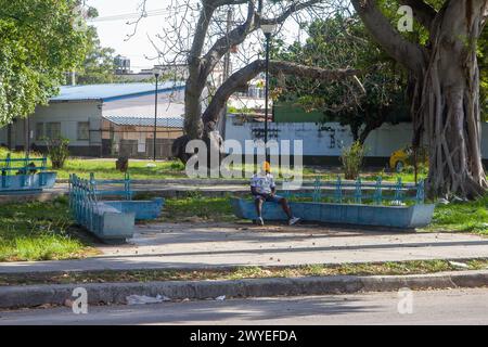 Ein einsamer Mann sitzt auf einer Bank auf einem Platz in Havanna, Kuba Stockfoto
