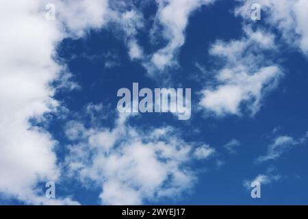 Wolkenhaufen verstreut am blauen Himmel mit Copyspace für Text. Stockfoto