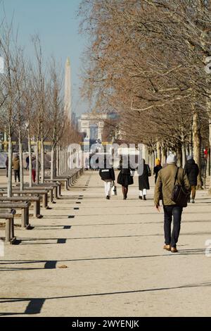 Mann In Winterkleidung, Spaziergang Durch Die Jardin Des Tuileries Mit Dem Arc De Triomphe Und Place De La Concorde Im Hintergrund, Paris Frankreich Stockfoto