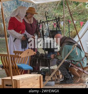 Darsteller aus der Bowlore-Truppe in mittelalterlichen Kostümen in ihrem Lager für die lebende Geschichte im Bishops Palace, Wells, Somerset, England, Großbritannien, 2022 Stockfoto