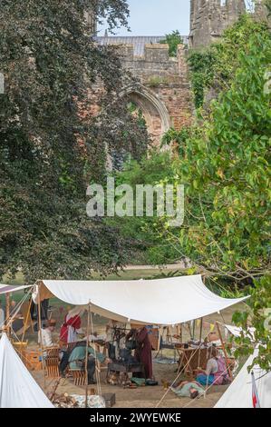 Darsteller aus der Bowlore-Truppe in mittelalterlichen Kostümen in ihrem Lager für die lebende Geschichte im Bishops Palace, Wells, Somerset, England, Großbritannien, 2022 Stockfoto