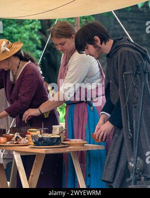 Darsteller aus der Bowlore-Truppe in mittelalterlichen Kostümen in ihrem Lager für die lebende Geschichte im Bishops Palace, Wells, Somerset, England, Großbritannien, 2022 Stockfoto