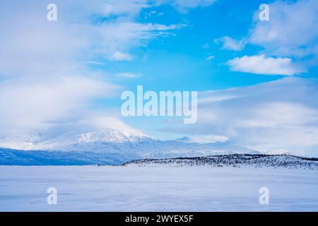 Gefrorener See Tornetrask und schneebedeckte Berge rund um Abisko, Schweden Stockfoto