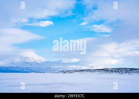 Gefrorener See Tornetrask und schneebedeckte Berge rund um Abisko, Schweden Stockfoto