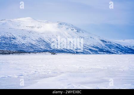 Gefrorener See Tornetrask und schneebedeckte Berge rund um Abisko, Schweden Stockfoto