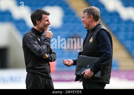 Colchester United Manager Danny Cowley (links) und Wrexham Manager Phil Parkinson (rechts) sprechen vor dem Spiel der Sky Bet League Two im JobServe Community Stadium in Colchester. Bilddatum: Samstag, 6. April 2024. Stockfoto