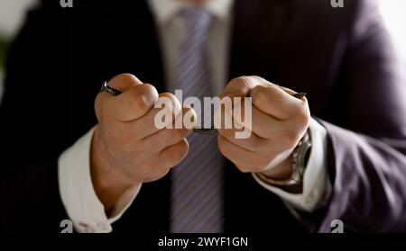 Mann in Anzug und Krawatte Nagel Biegung mit Waffen closeup Stockfoto