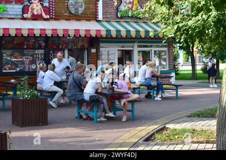 Im Stadtpark kommunizieren die Leute, während sie in Einem Café sitzen. Stockfoto