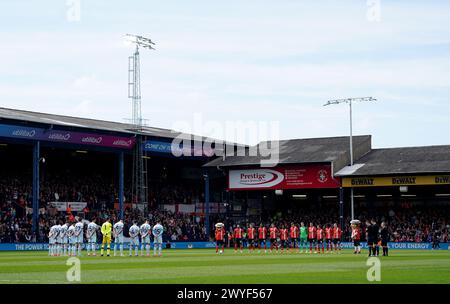 Die Spieler beider Mannschaften halten eine Schweigeminute für die vier ehemaligen Spieler von Luton Town, Ron Baynham, Jimmy Ehemann, Billy Kellock und Chris Nicholl, bevor sie in der Kenilworth Road in Luton das Premier League-Spiel absolvieren. Bilddatum: Samstag, 6. April 2024. Stockfoto