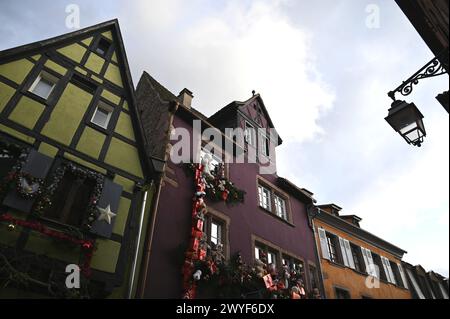 Malerischer Blick auf Fachwerkhäuser mit festlicher Weihnachtsdekoration auf der Rue du Général de Gaulle, der Hauptstraße von Riquewihr im Elsass, Frankreich. Stockfoto