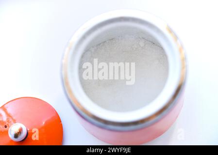 Rote Keramik-Zuckerschale auf weißem Hintergrund. Zucker in einem Glas. Stockfoto