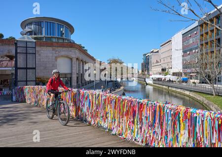 Nette ältere Frau, die mit ihrem E-Mountainbike in der malerischen Stadt Aveiro, Portugal, radelt Stockfoto