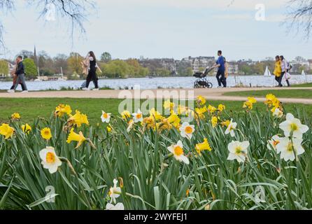 Hamburg, Deutschland. April 2024. Wanderer schlendern bei angenehmen Temperaturen entlang der Außenalster. Quelle: Georg Wendt/dpa/Alamy Live News Stockfoto