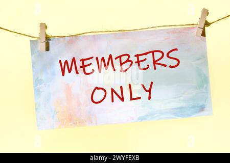 NUR ein Text, der auf einem Stück Papier geschrieben ist, das an einem Seil mit Kleiderschalen befestigt ist Stockfoto