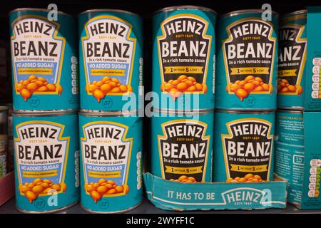 Großaufnahme von Dosen von Heinz Baked Beans in einem Supermarktregal, England, Großbritannien Stockfoto
