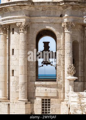 Der Glockenturm der Kathedrale von Cadiz, Nahaufnahme einer katholischen Kirchenglocke, Meereshorizont mit Schiff im Hintergrund Stockfoto