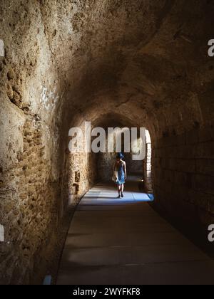 Unterirdischer Tunnel am römischen Theater von Cádiz mit einer jungen Frau in Sommerkleid, die als Teatro Romano de Cádiz bekannt ist, Andalusien, Spanien Stockfoto