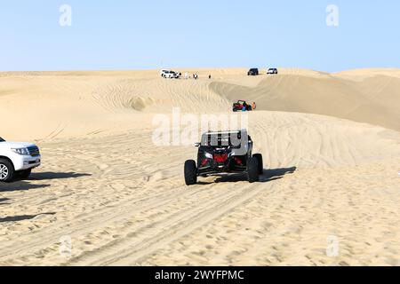 Blick auf Dünen-Buggys, die von Touristen in einem Wüsten-Safari-Park in den Sanddünen in der Nähe des Binnenmeers gefahren werden. Stockfoto