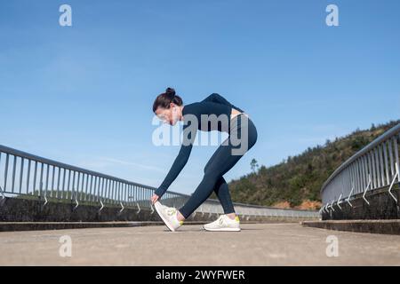 Läuferin, die draußen Dehnungsübungen für die Beine macht Stockfoto