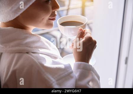 Erwachsene Frau genießt ihren Morgenkaffee auf dem Balkon Stockfoto