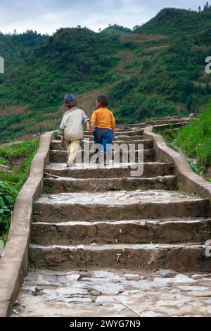 Zwei kleine Jungen aus einem Dorf aus einem Bergstamm, die Hand in Hand in Hand in der Nähe von Sapa in Vietnam in Südostasien gehen Stockfoto