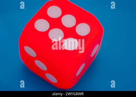 Glücklicher Gewinner, rote Würfel vor blauem Hintergrund, die sechs zeigen Stockfoto