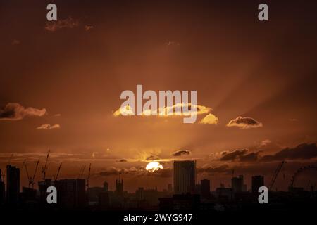 London, Großbritannien. April 2024. Wetter in Großbritannien: Sturm Kathleen bringt einen dramatischen Sonnenuntergang und Abendlicht über die Gebäude der Stadt und endet am Samstag. Guy Corbishley/Alamy Live News Stockfoto