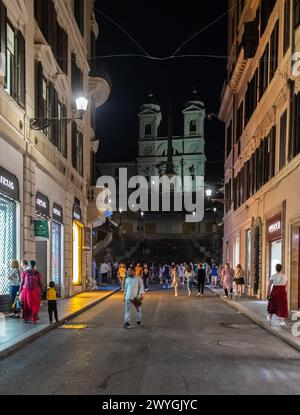 ROM, ITALIEN - 24. MAI 2022: Eine Wohnstraße in Rom, wo die Menschen draußen in einem kleinen Restaurant auf einer alten Kopfsteinpflasterstraße speisen Stockfoto