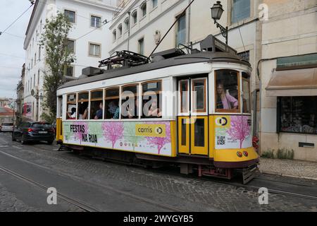 Der berühmte gelbe Trolley fährt durch die ältesten Viertel Lissabon, Portugal. Der gelbe Trolley ist bei Touristen sehr beliebt. Stockfoto