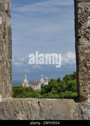 Blick auf eine Kirche von einem Fenster in der Verteidigungsmauer von St. George's Castle. Lissabon, Portugal. Stockfoto