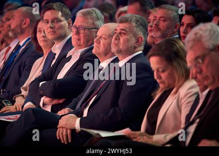 Bukarest, Rumänien. April 2024: Nicolas Schmit (C-L), Spitzenkandidat der SPE für die EU-Wahlen, Olaf Scholz (C), Bundeskanzler von Deutschland, und Marcel Ciolacu (C-R), Premierminister Rumäniens und Präsident der Sozialdemokratischen Partei (PSD), nehmen an der Konferenz der Sozialdemokratischen Partei Europas (SPE) "Wir stehen zusammen - für unser Europa!" Teil, die im Palast des rumänischen Parlaments stattfand. Quelle: Lucian Alecu/Alamy Live News Stockfoto