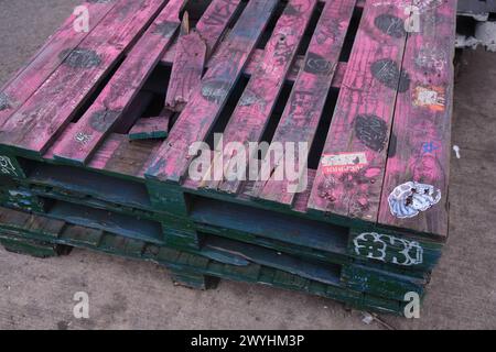 Holzpaletten. Gebrauchte Holzpaletten aufeinander gestapelt. Transport und Lagerung. Holzpaletten auf dem Bürgersteig. Holzpaletten. Flache Ausführung, oben Stockfoto