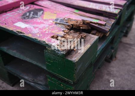 Holzpaletten. Gebrauchte Holzpaletten aufeinander gestapelt. Transport und Lagerung. Holzpaletten auf dem Bürgersteig. Holzpaletten. Flache Ausführung, oben Stockfoto