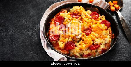 Trendiges Hybrid-Essen. Mac und Käse Pizza auf dunklem Hintergrund. Banner, Kopierbereich Stockfoto